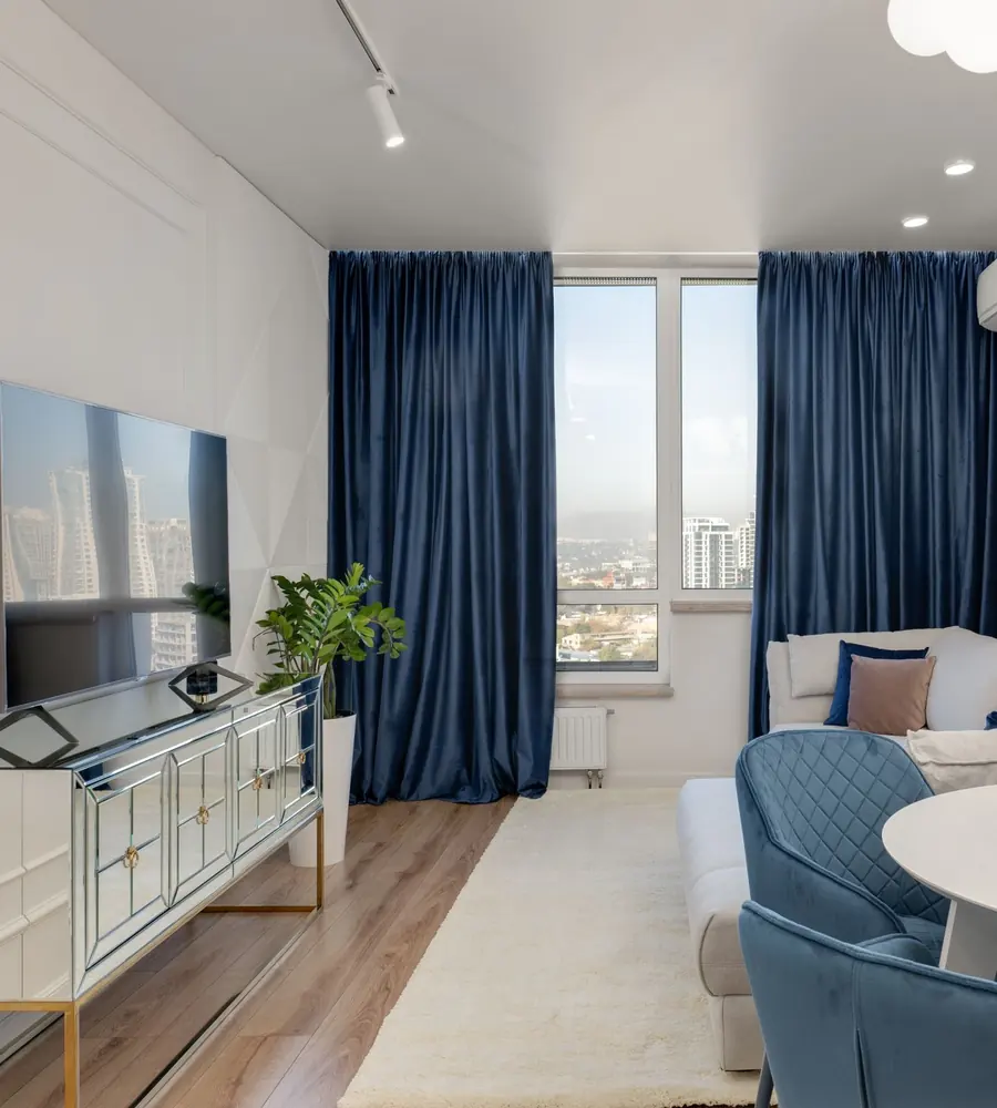 A bright living room with deep blue velvet curtains